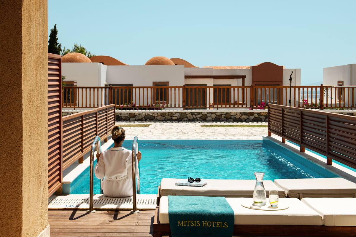 Ein Poolbereich mit Liegestuhl, Handtuch und Wasserflasche, der einen Hotelbetrieb andeutet.