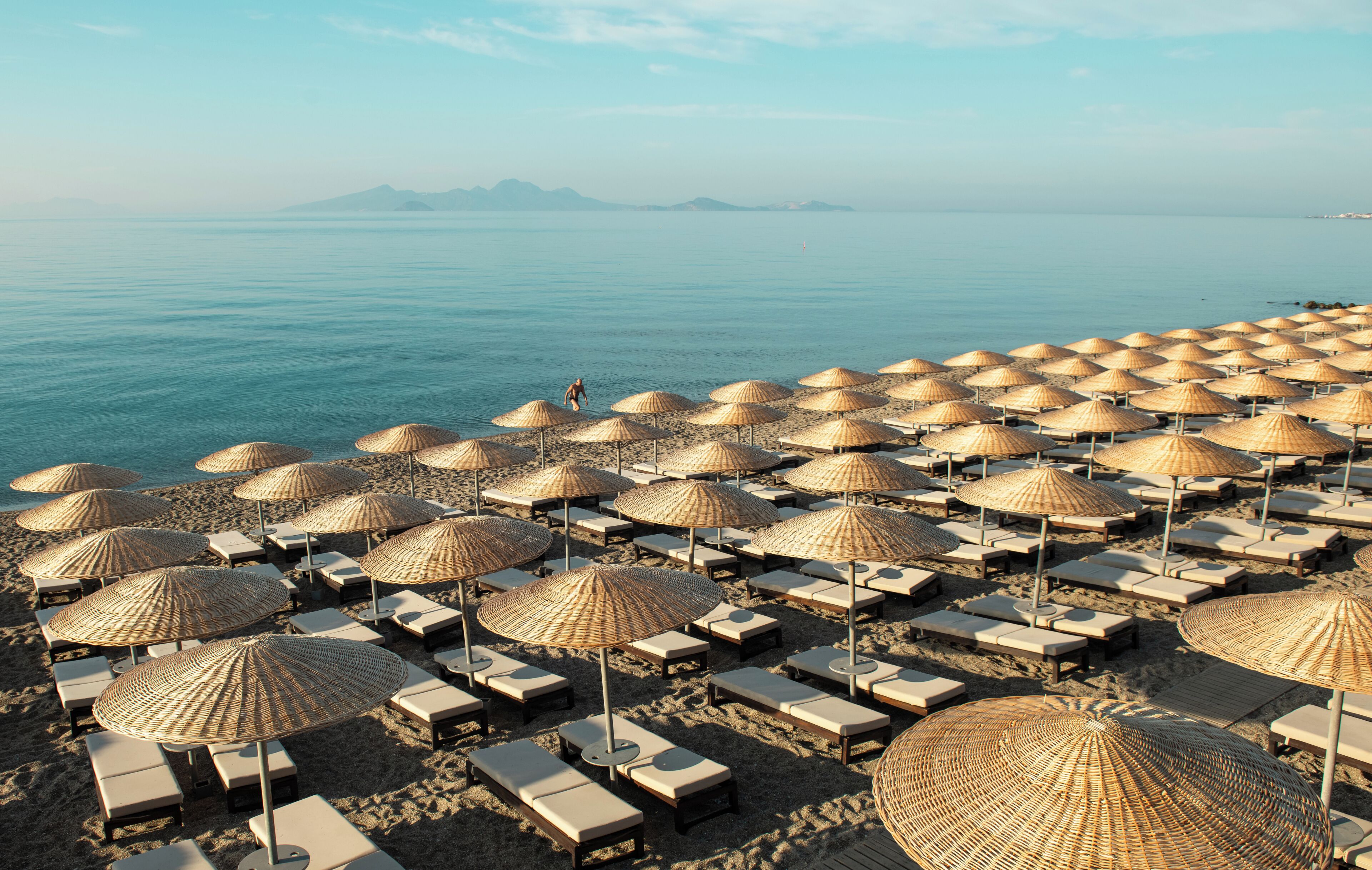 On the beach, black sand, sun loungers, beach umbrellas
