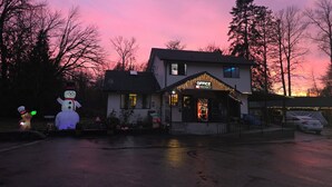 A building with a 'NO VACANCY' sign, a snowman decoration, and a car parked in front. - Monroe Motel Near Seattle Everett WA (Monroe)