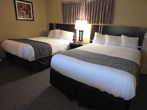 Two single beds with headboards, a nightstand with a lamp, and a framed picture on the wall. - Monroe Motel Near Seattle Everett WA (Monroe)