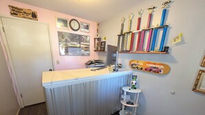 A kitchen with a marble countertop, a clock, framed photos, trophies, and a small shelf with a gnome figure. - Monroe Motel Near Seattle Everett WA (Monroe)