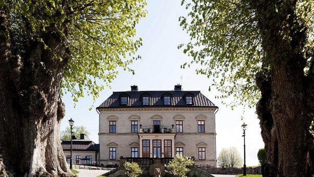 A large, historic building with a symmetrical facade, central entrance, and a well-maintained lawn. - Görvälns Slott (Jarfalla)
