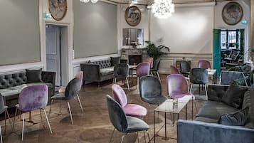 Amplia sala de estar con diversas opciones de asientos, incluyendo sofás, sillones y una mesa de comedor.