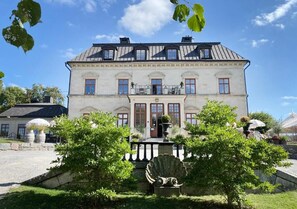 A large, two-story building with a symmetrical facade, large windows, and a central entrance. - Görvälns Slott (Jarfalla)