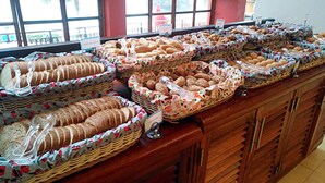 En buffet med forskellige brød og kager anrettet i fletkurve.