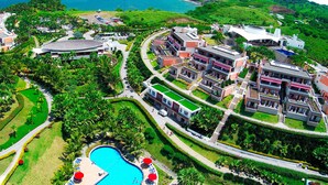 Et resort med swimmingpool, frodig vegetation og havudsigt.