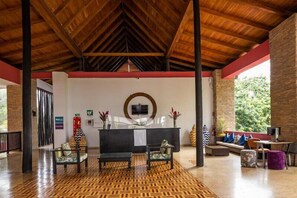 A lobby with a reception desk, seating area, and a patterned floor. - Decameron Baru - All inclusive (Cartagena)