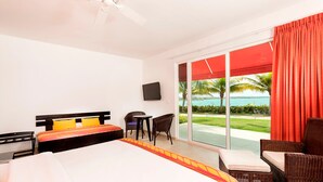 A hotel room with a bed, a desk, a chair, and a view of the ocean.