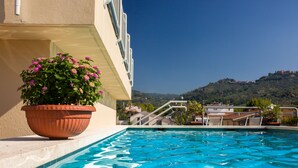 Una piscina con vistas a una colina y un edificio al fondo.