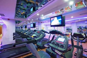 A gym with multiple treadmills, a television screen, and a ceiling with a unique design. - The City Hotel (Istanbul)