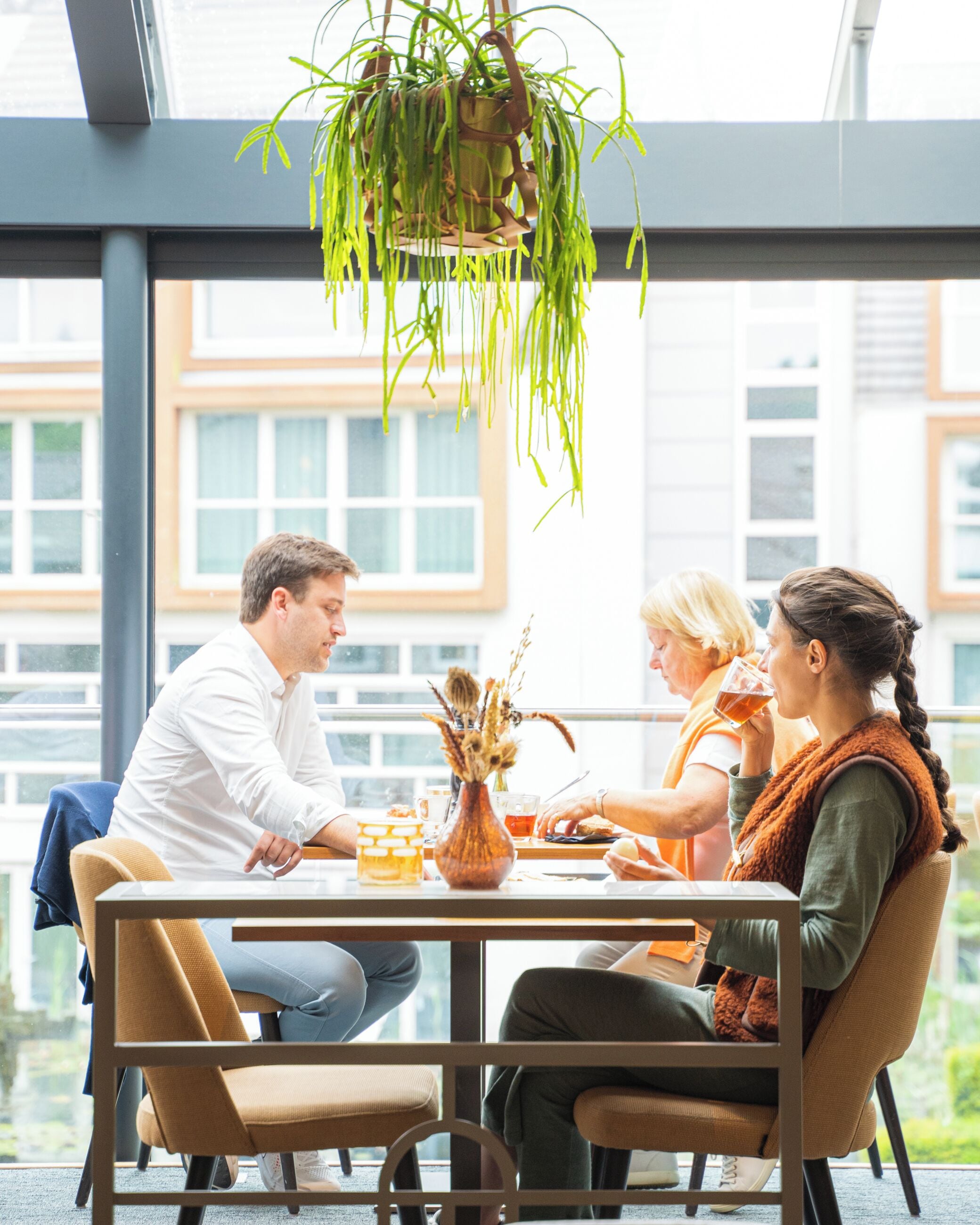 A dining area with a table, chairs, and hanging plants.