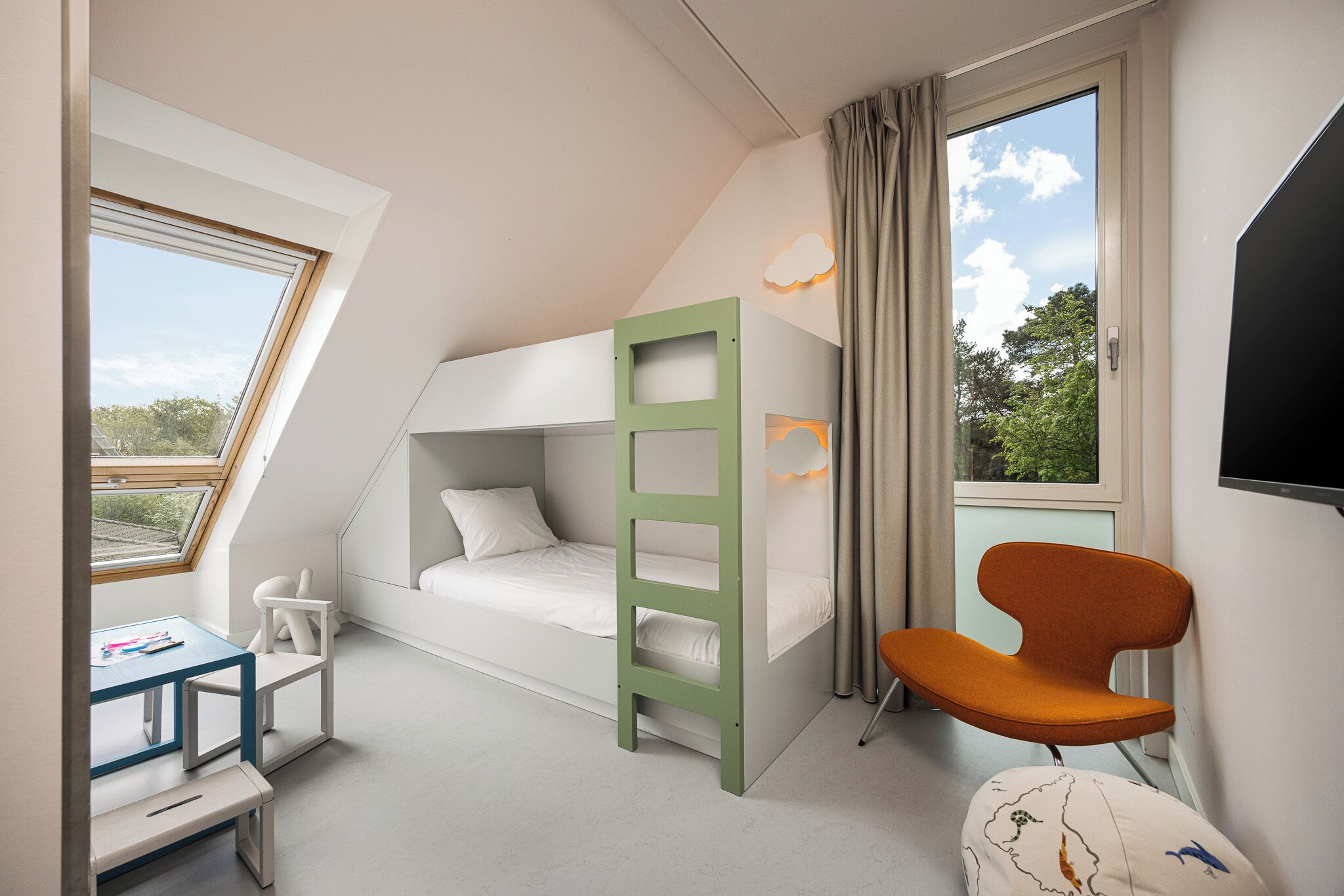 Une chambre avec un lit superposé, un bureau, une chaise et un téléviseur.