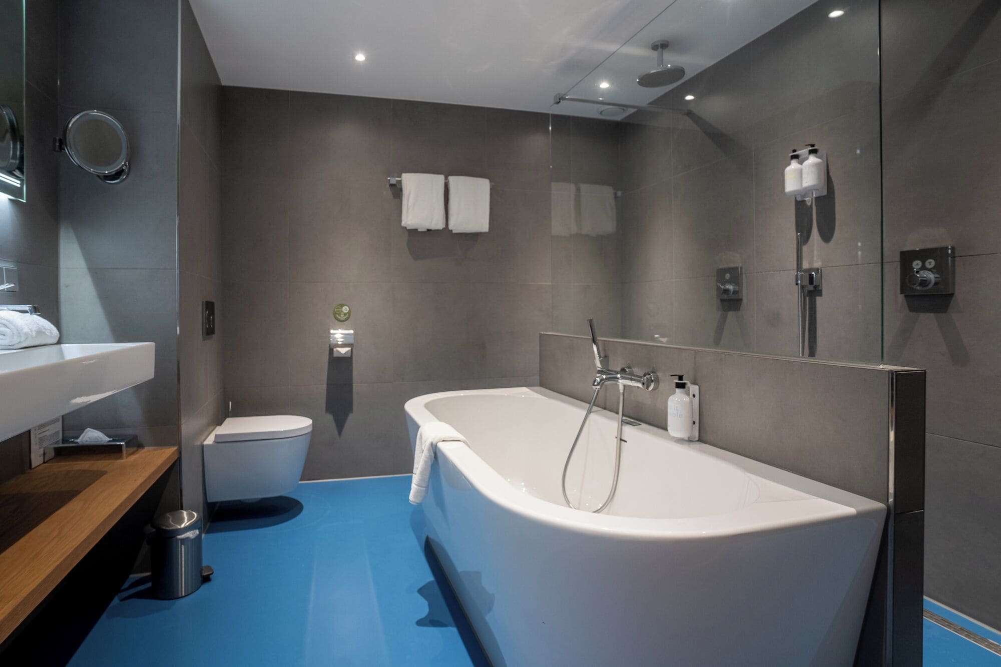 Une salle de bain moderne équipée d’une baignoire, de toilettes et d’un lavabo.