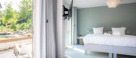Un dormitorio moderno con una cama grande, una mesita de noche y una lámpara colgante.