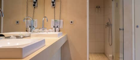 Ein modernes Badezimmer mit zwei Waschbecken, einer Dusche und einer gläsernen Duschkabine.
