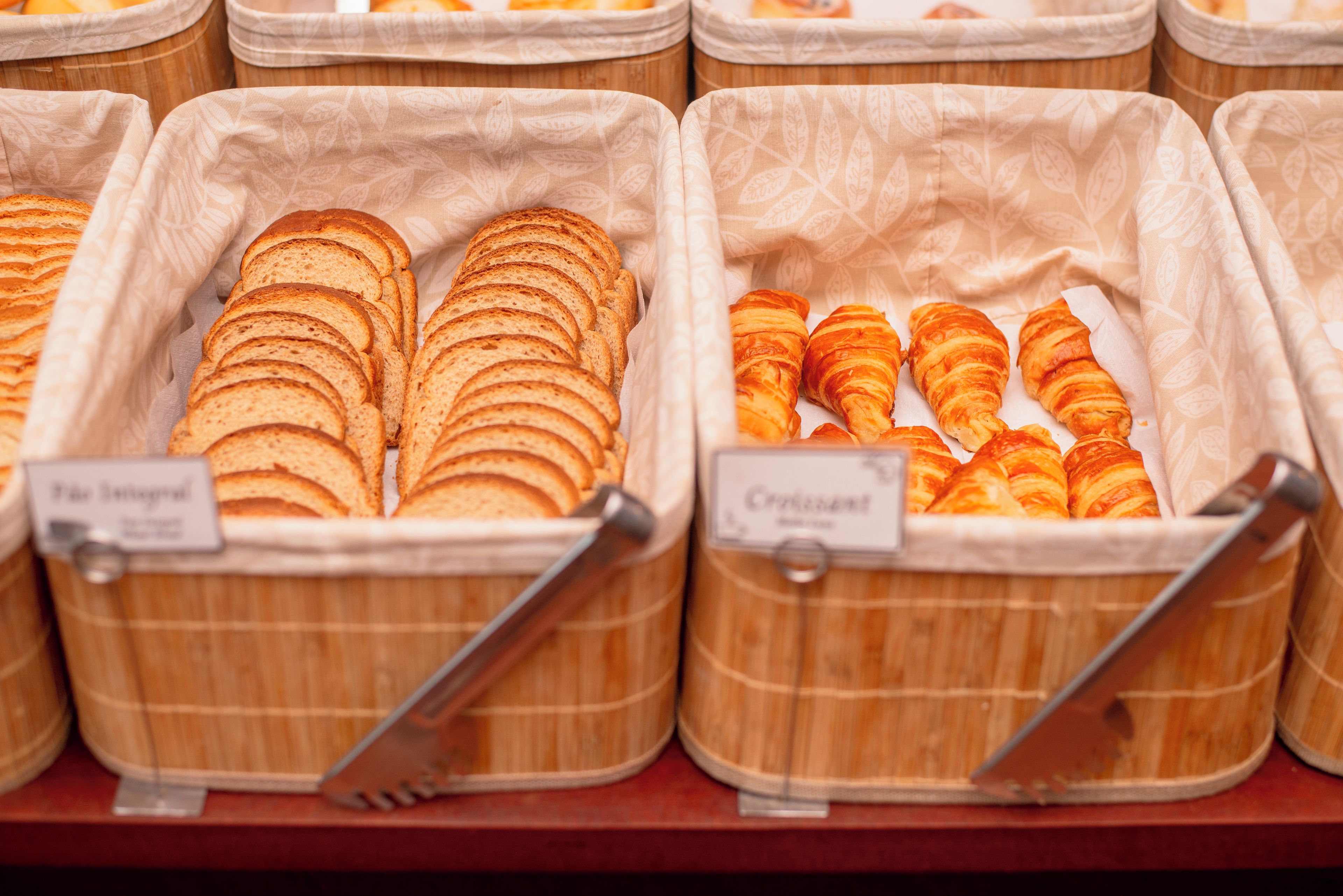Vitrinas de panadería con panes y pasteles etiquetados.