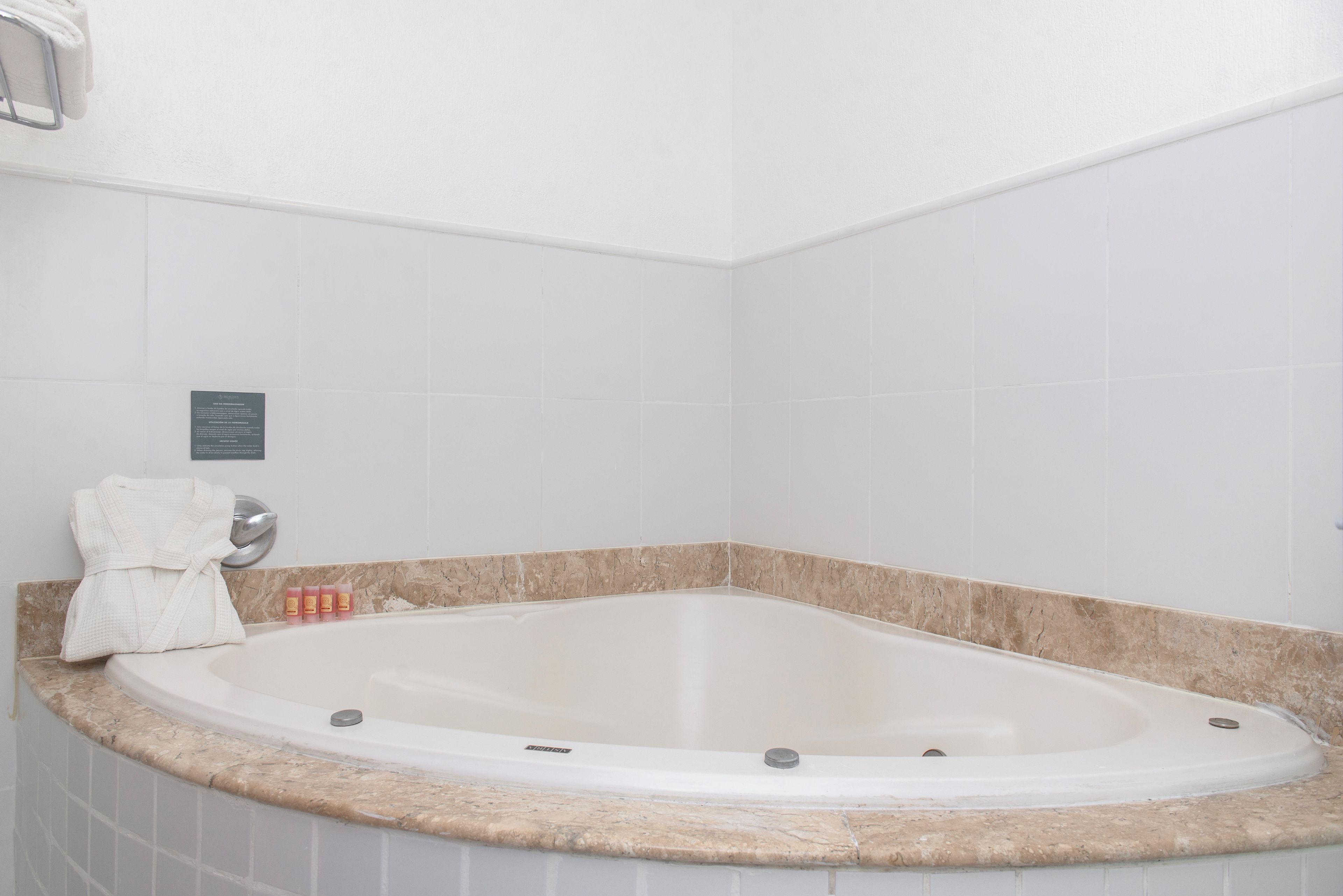 A bathroom with a freestanding bathtub, a towel rack, and a small plaque on the wall.