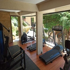 A gym with treadmills, a stationary bike, and a rowing machine.