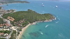 Vista aérea de un pueblo costero con playa, barcos y un crucero.