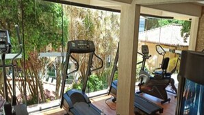 Une salle de sport équipée de tapis de course, d’un vélo d’appartement et d’un appareil d’aviron.