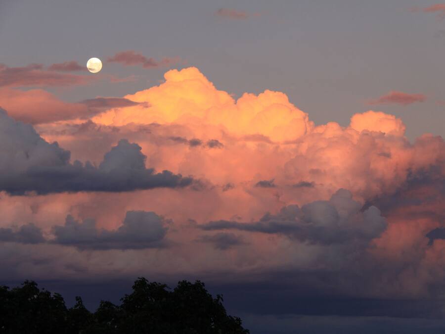 A landscape with a prominent moon and clouds.