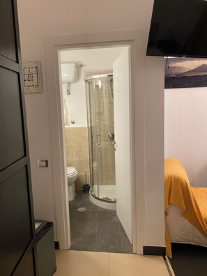 Une salle de bain avec une douche à parois de verre, des toilettes et un lavabo.