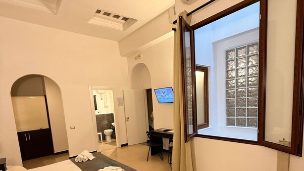 Une chambre d’hôtel moderne, dotée d’un grand lit, d’un bureau et d’une télévision.