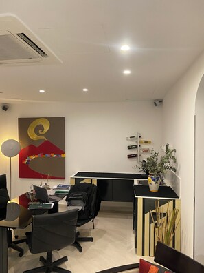 Un espace de bureau moderne comprenant un bureau, une chaise, un ordinateur portable et une plante en pot.