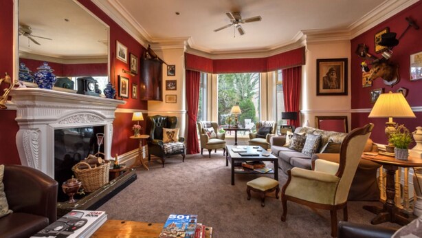 A traditional living room with a fireplace, comfortable seating, and a view of the outdoors. - Cheshire Hospitality Ltd T/A Lennox Lea Studios & Apartments (Sale)