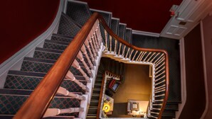 A spiral staircase with a wooden handrail and carpeted steps. - Cheshire Hospitality Ltd T/A Lennox Lea Studios & Apartments (Sale)