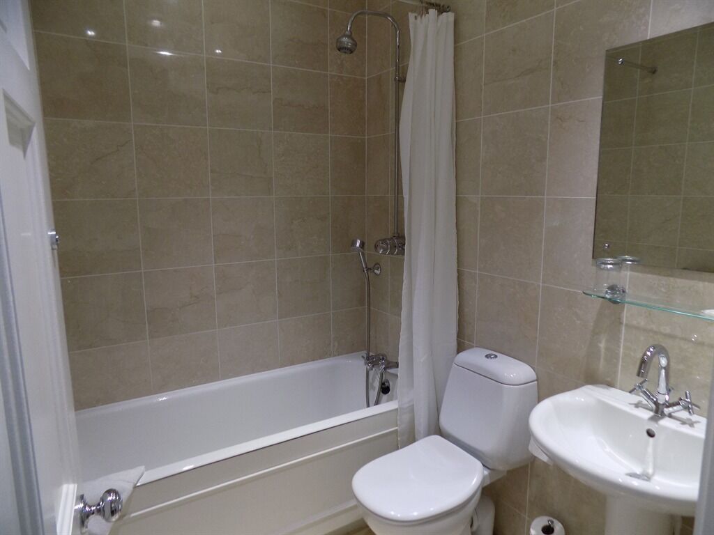 A bathroom with a bathtub, toilet, and sink.