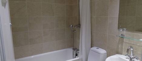 A bathroom with a bathtub, toilet, and sink.