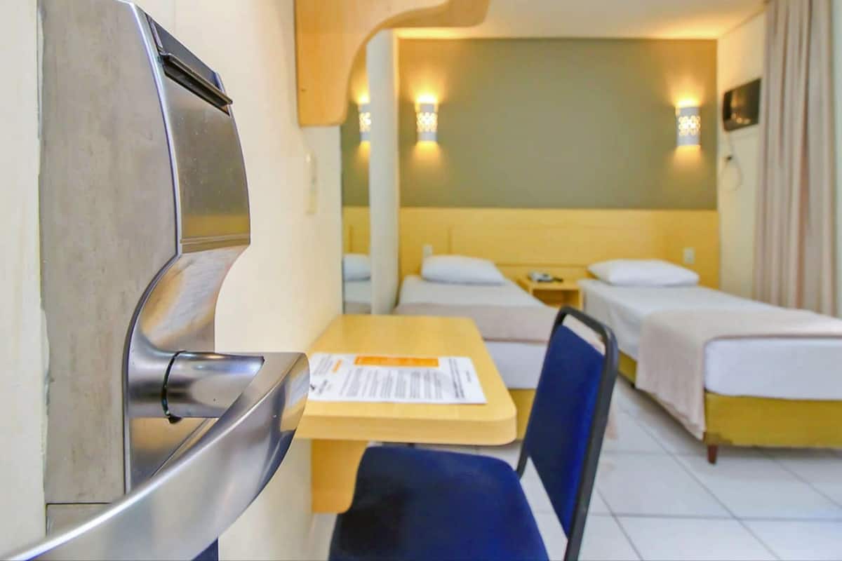 A hotel room with a bed, a desk, and a chair.