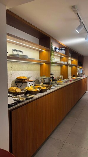 A buffet setup with various food items and utensils, wooden paneling, and a sign indicating a service area. - Coral Express (Porto Alegre)