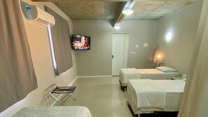 A hotel room with two beds, a TV, and a bathroom with a shower. - Coral Express (Porto Alegre)