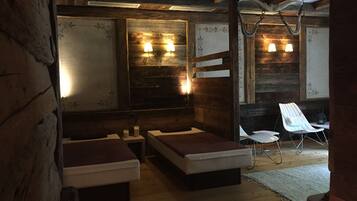 Relax in a cozy space with a large mirror, two wall-mounted lamps, and a seating area with wooden benches and cushions.