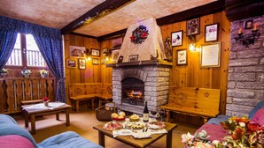Una habitación acogedora con chimenea de piedra, muebles de madera y una mesa de comedor servida con comida.