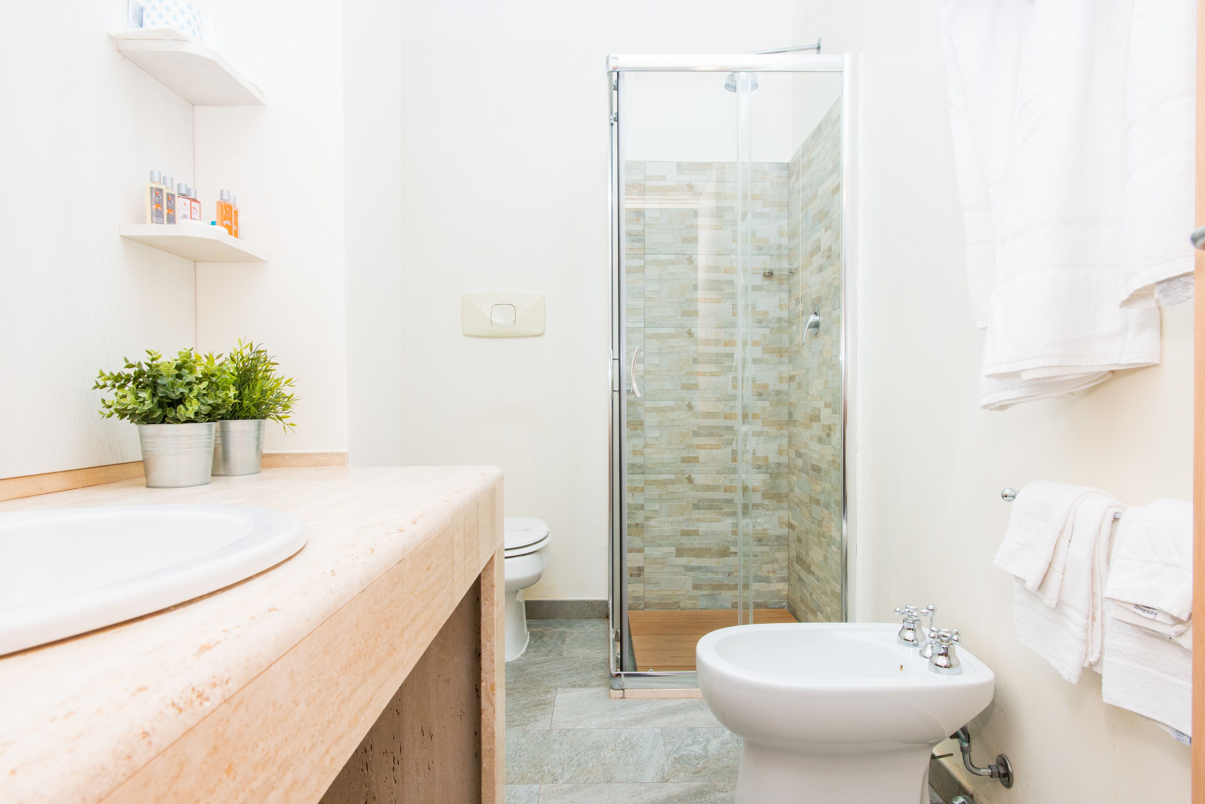 Une salle de bain avec une douche à parois de verre, un lavabo et des toilettes.