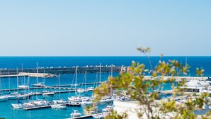 A marina with numerous boats docked, a clear blue sky, and a distant view of the sea. - Approdo Boutique Hotel Leuca (Castrignano del Capo)