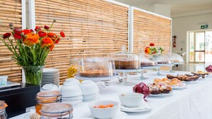 A buffet table with various food items and a vase of flowers. - Approdo Boutique Hotel Leuca (Castrignano del Capo)