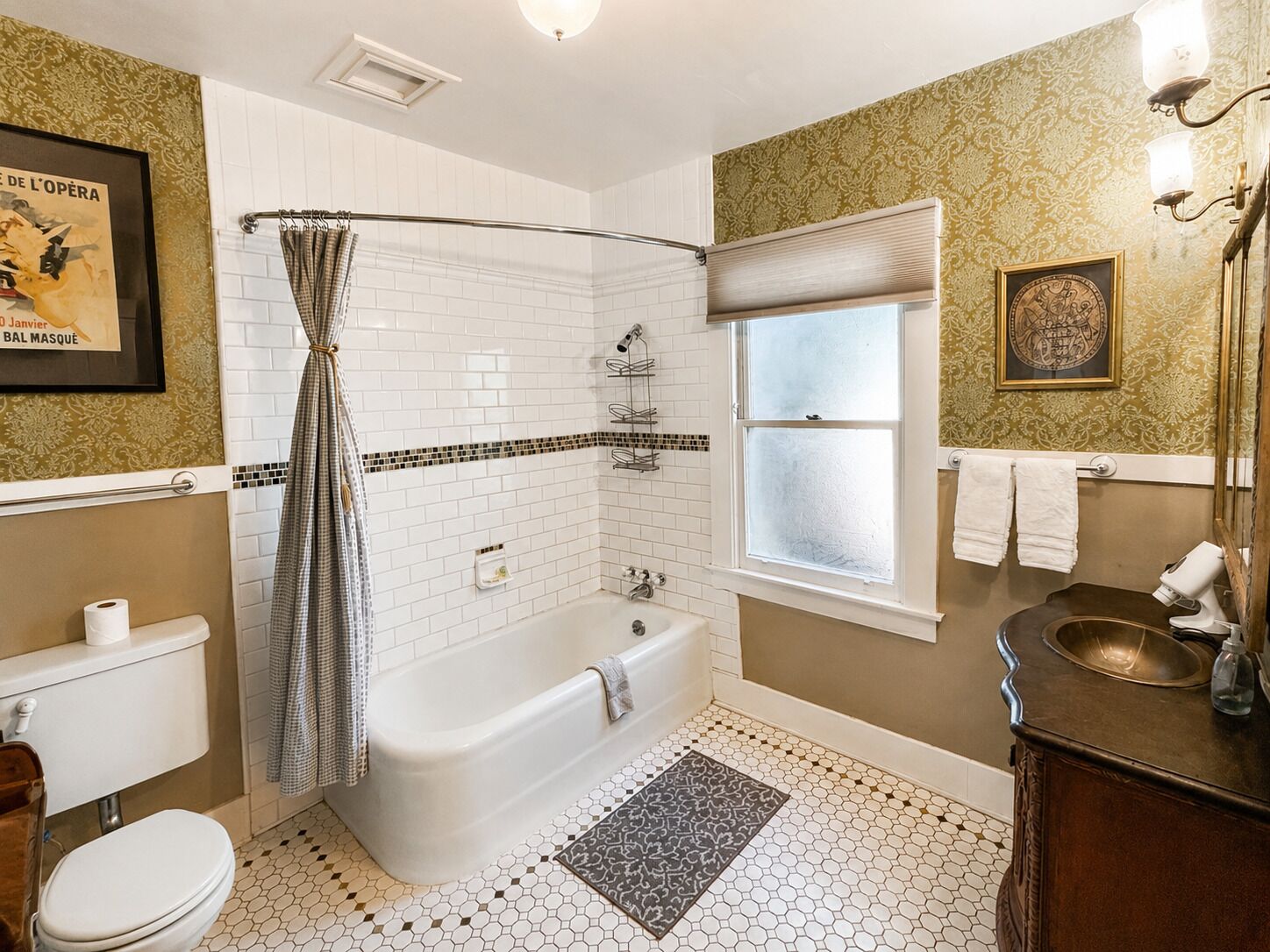 Une salle de bain avec une baignoire, des toilettes, une douche et une fenêtre.