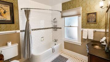 Une salle de bain avec une baignoire, des toilettes, une douche et une fenêtre.
