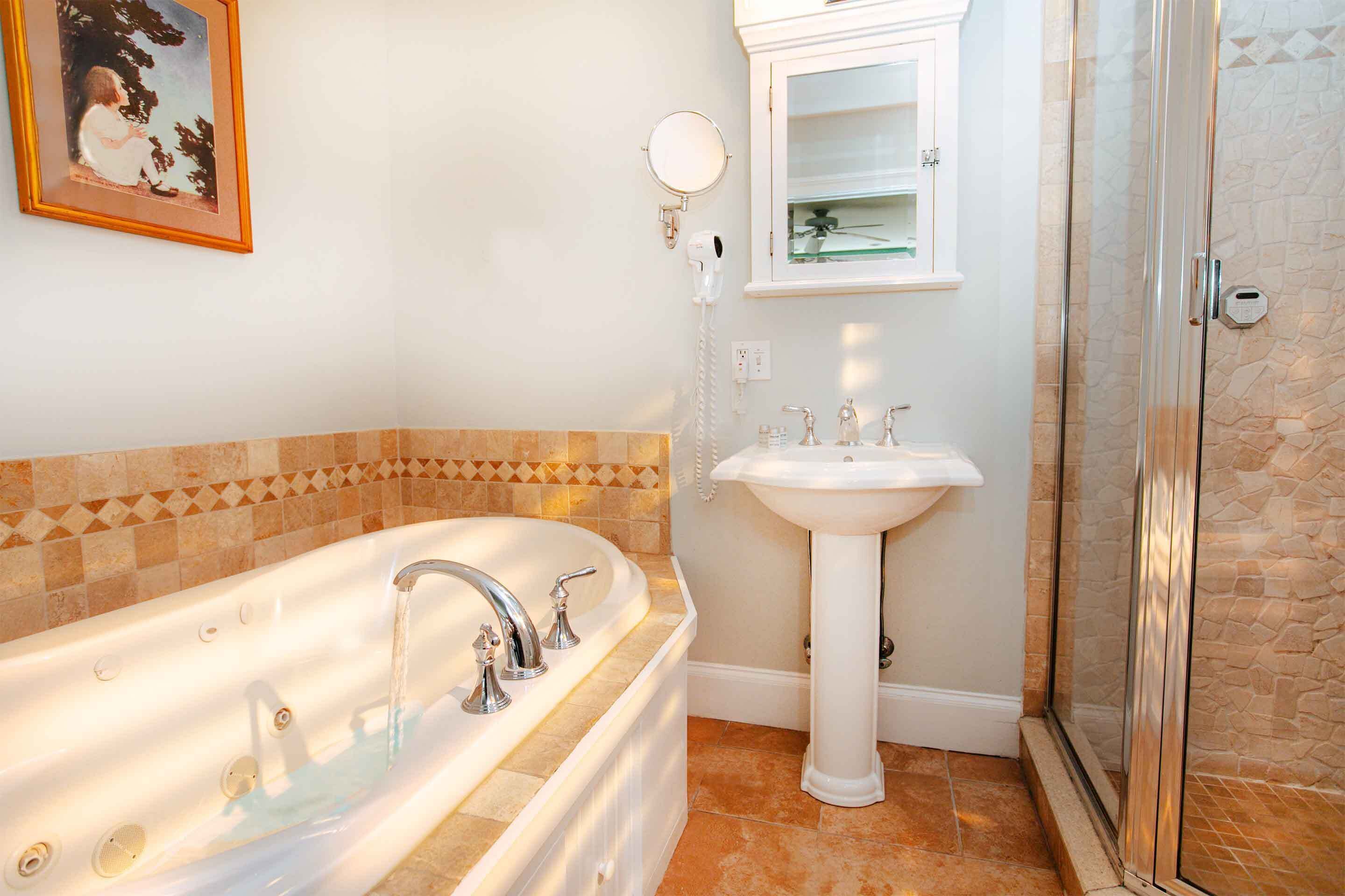 A bathroom with a bathtub, a sink, and a shower.