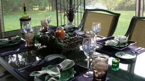 Een eettafel gedekt voor twee met uitzicht op een tuin.