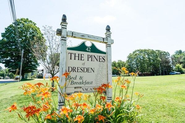 Señalización del Bed & Breakfast 'The Pines of Dresden' con techo verde y el número 42 en la parte superior.