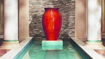 Stunning vase sits atop a tiled platform, flanked by two columns.