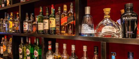 A variety of liquor bottles on shelves in a bar setting.