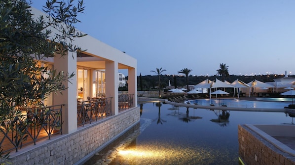 A resort pool area with a bar and umbrellas. - Vale d'Oliveiras Quinta Resort & Spa (Lagoa)