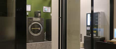 Une buanderie moderne équipée d’un lave-linge, d’un sèche-linge et d’un écran d’ordinateur.