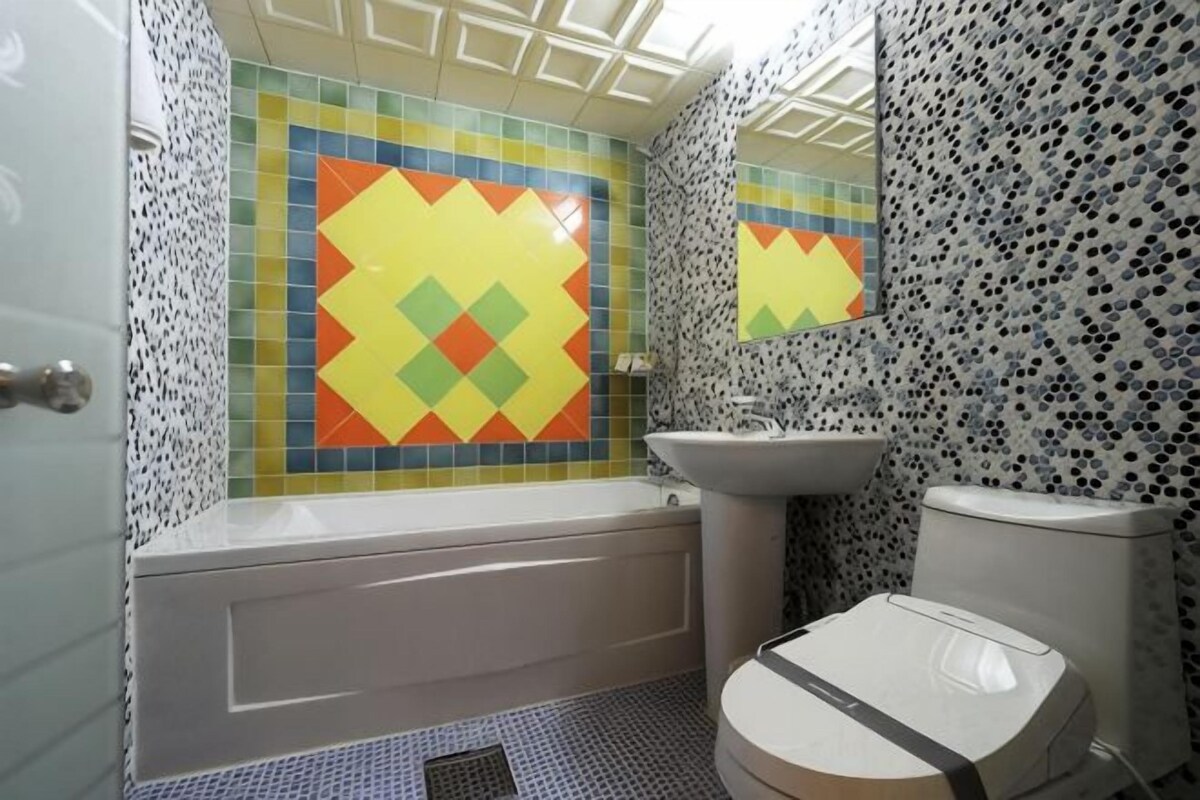 Een badkamer met bad, wastafel en toilet.